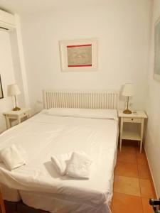 ネルハにあるApartment over torrecilla beach promenadeの2泊用のスタンド付きの客室の白いベッド1台