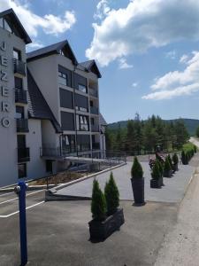 un edificio con una fila di alberi in vaso di fronte di Studio Lola Jezero a Divčibare