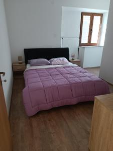 - un grand lit violet dans une chambre dotée de parquet dans l'établissement Valentino, à Senj