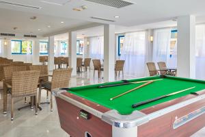 a pool table in a room with tables and chairs at Ilusion Vista Blava in Cala Millor