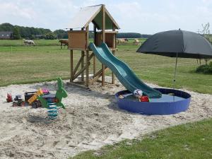 a playground with a slide and an umbrella at Comfort Safaritent Jungle - 6 personen in Zwiggelte