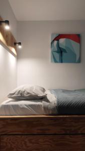 APARTAMENT STAROWIEJSKA 33 في غدينيا: سرير في غرفة نوم مع لوحة على الحائط