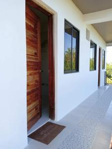 an open wooden door of a house with a window at Reinhardshausen Suites and Residences - Cozy Air-conditioned Units in Tuguegarao City