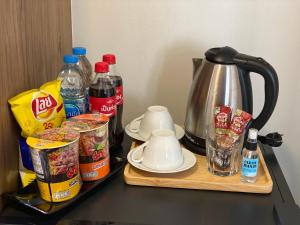 Casa Luxe Hotel and Resident في بانكوك: كونتر مع وعاء القهوة وبعض المواد الغذائية والمشروبات