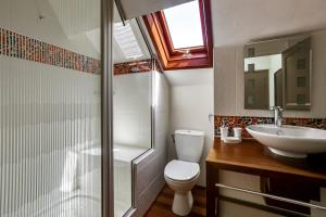 a bathroom with a shower and a toilet and a sink at Magnifique loft au-dessus de l'océan, place de parking in Biarritz +15 photos