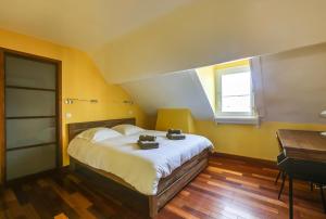 a bedroom with a bed and a desk and a window at Magnifique loft au-dessus de l'océan, place de parking in Biarritz