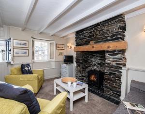 a living room with a large stone fireplace at Homelands in Port Isaac