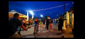 a group of people on a street at night at Pure BLISS Luxury Beachfront Apartment with Panoramic Sea Views, Electric BBQ and More in Agia Triada