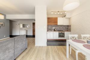 kuchnia na otwartym planie i jadalnia z białymi szafkami w obiekcie Shum Jeziora Apartament nr 7 w mieście Giżycko