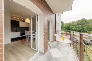 balkon ze stołem i krzesłami oraz kuchnią w obiekcie Shum Jeziora Apartament nr 7 w mieście Giżycko