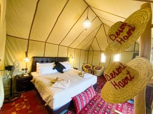 a bedroom with a bed and chairs in a tent at Desert Heart Luxury Camp in Merzouga
