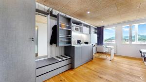 a room with a kitchen with a desk and some windows at Evi's Home Hotel & Apartments in Bern