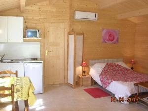eine Küche und ein Schlafzimmer mit einem Bett in einer Hütte in der Unterkunft Chalet l'emiline , Gite climatisé au sud d'aix avec piscine in Bouc-Bel-Air
