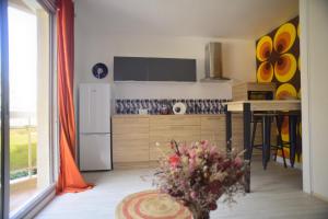 a kitchen with a table and a white refrigerator at Studio POP Canet En Roussillon in Canet-en-Roussillon