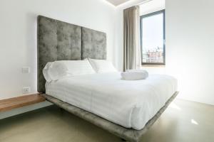 a bedroom with a large white bed with a large window at DOMUS CAVOUR Rooms&Suites in Tirano