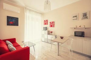 un soggiorno con divano rosso e tavolo di Morgana Central Apartment by Wonderful Italy a Sanremo