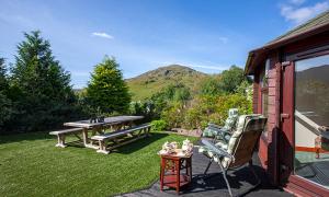 un patio trasero con una mesa de picnic y un banco en Mullach Ruadh, en Corpach