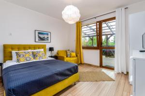 1 dormitorio con cama amarilla y silla amarilla en Ośrodek Wypoczynkowy Karolina en Stegna