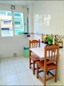 a kitchen with a white table and two chairs at Love&Frogs in Almuñécar +3 photos