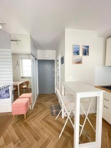 Il comprend une cuisine et une salle à manger avec une table et des chaises blanches. dans l'établissement Apartament Lenka, à Dziwnówek