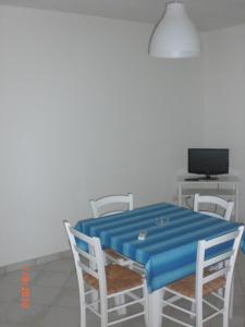 ポルト・チェザーレオにあるChiusurelle Apartmentsのテーブル、椅子、青いテーブル、テレビ付
