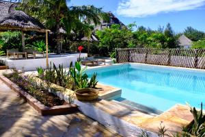 uma piscina num resort com plantas em Nyumbani Residence Apartments em Jambiani