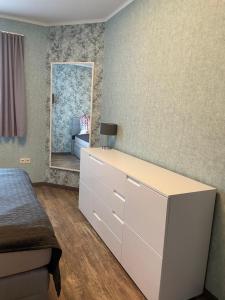 ein Schlafzimmer mit einer weißen Kommode und einem Spiegel in der Unterkunft Zum Geigenmüller in Stützengrün