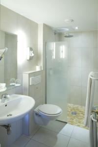 a bathroom with a sink, toilet, and shower at Grand Hôtel Bristol in Colmar