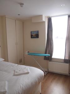 a bedroom with a bed and a table next to a window at Marble Arch Flats in London
