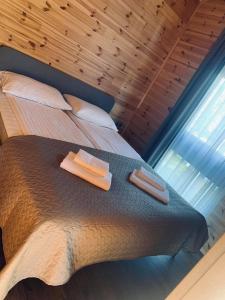 um quarto com uma cama com duas toalhas em NB Houses Šventoji em Šventoji