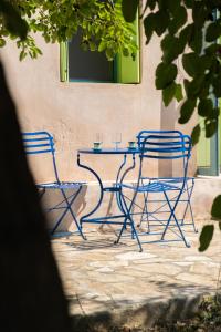 duas cadeiras azuis e uma mesa em frente a um edifício em Simboro house - Kythoikies holiday houses em Kýthira