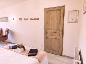 a room with a bed with a wooden door at La Saint Martinoise in Saint-Martin-Boulogne