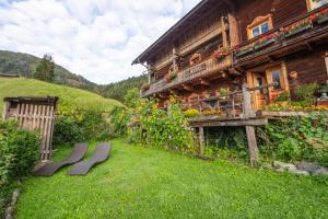 ein Holzhaus mit einer Bank im Hof in der Unterkunft Familienwanderhof Eggeler in Liesing