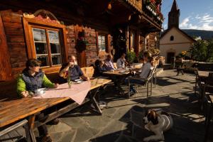 un grupo de personas sentadas en mesas en un restaurante en Familienwanderhof Eggeler, en Liesing