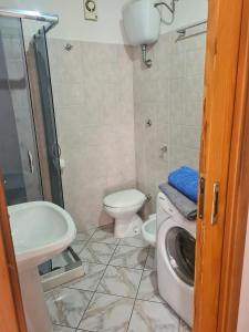 y baño con aseo, lavabo y lavadora. en Ianua Room - Casa Vacanze, en Vasto