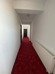 a long corridor with a red carpet in a white room at Vila Gymy in Constanţa