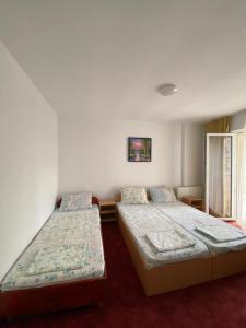 1 dormitorio con 2 camas y ventana en Vila Gymy, en Constanţa