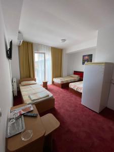 a hotel room with two beds and a refrigerator at Vila Gymy in Constanţa