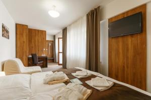 a hotel room with a bed with towels on it at Hotel Termál in Vyhne