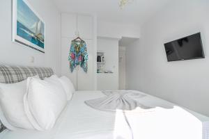 a white bedroom with a bed with white pillows at Arolithos in Spetses