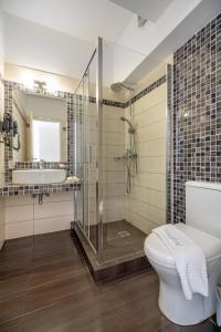 a bathroom with a shower and a toilet and a sink at Arolithos in Spetses