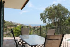 a table and chairs on a balcony with a view of the ocean at Agriturismo Azzurra Biricchina - Suites in Riva Ligure