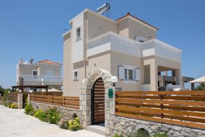 a villa with a gate in front of a house at Prinos Oasis Twin Villas III in Prínos