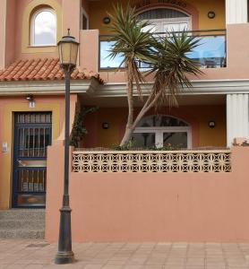 światło uliczne przed domem z palmą w obiekcie Casa Natal. Tú rincón acogedor en El Cotillo. w mieście Cotillo