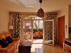salon z kanapą i przesuwnymi szklanymi drzwiami w obiekcie Casa Natal. Tú rincón acogedor en El Cotillo. w mieście Cotillo