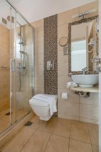a bathroom with a toilet and a sink and a shower at Arolithos in Spetses