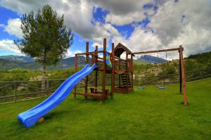 a playground with a blue slide in the grass at Casas Ordesa y Casa Altemir in Belsierre