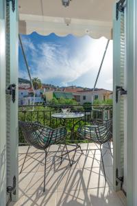 a patio with a table and chairs on a balcony at Arolithos in Spetses