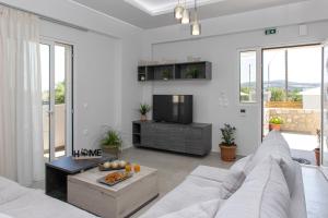 salon z białą kanapą i telewizorem w obiekcie Prinos Oasis Twin Villas III w mieście Prínos