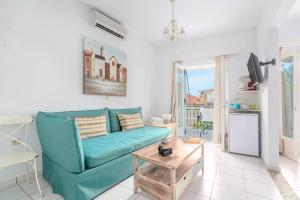 a living room with a blue couch and a table at Arolithos in Spetses